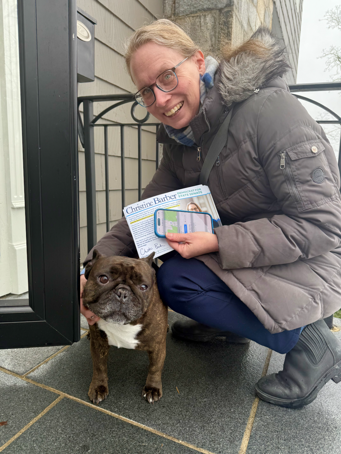 Christine Barber canvassing at a doorstep, greeting a dog